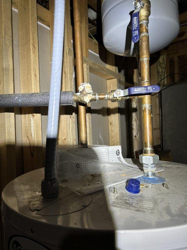 Responded to intermittent water leak in basement plumbing system. Upon inspection, identified leak source at copper pipe connections near water heater. Examined ball valves, brass fittings, and solder joints on vertical and horizontal copper supply lines. Tightened connections at T-fitting junctions and replaced compromised brass fittings where corrosion and age had degraded seals. Verified all shut-off valves were functioning properly and confirmed pipe insulation was intact. Tested system under pressure to ensure leak was resolved and all connections remained dry. System restored to normal operation with no further signs of water seepage.