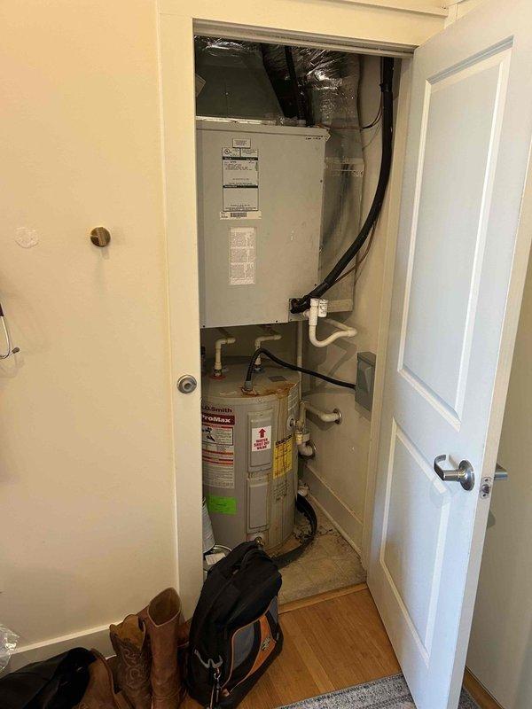 Responded to no cooling complaint on older electric HVAC system with indoor temperature reading 73°F while thermostat set to 68°F. Upon arrival, confirmed air handler blower operation but no refrigeration cycle. Accessed utility closet-mounted air handler and inspected system components. Observed significant age-related deterioration including oxidized copper tubing with visible patina formation and general wear consistent with 10+ year old equipment. Performed diagnostic evaluation of refrigeration system, electrical components, and capacitor function to determine root cause of cooling failure and provided repair recommendations to restore system operation.