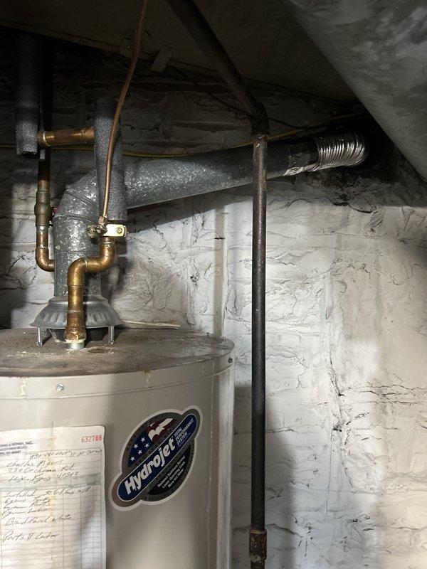 Installed proper venting system for HydroJet water heater by running a protective sleeve down the existing chimney shaft and routing 3-inch double-walled metal exhaust pipe through the sleeve to exit at the chimney top. Connected exhaust piping to water heater and verified proper venting operation to ensure safe combustion gas exhaust and code compliance.