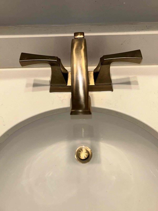 Responded to intermittent water leak reported under bathroom sink. Inspected undermount sink basin, faucet assembly with bronze finish geometric fixtures, and all supply line connections beneath vanity. Identified source of intermittent leak at supply line connection. Tightened compression fittings and verified proper seal. Tested system under full water pressure with no leakage detected. Additionally inspected gas appliance connections near stove per customer concern. Performed gas leak detection test using approved detection solution on all accessible connections and fittings. No gas leaks detected at stove area or surrounding connections. All systems operating properly upon completion.