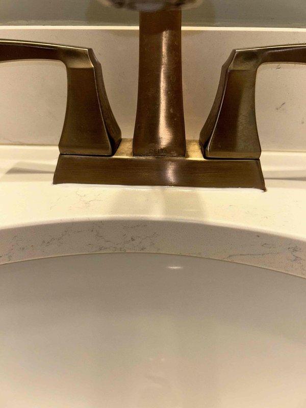 Responded to intermittent water leak reported under bathroom sink. Inspected undermount sink basin, faucet assembly with bronze finish geometric fixtures, and all supply line connections beneath vanity. Identified source of intermittent leak at supply line connection. Tightened compression fittings and verified proper seal. Tested system under full water pressure with no leakage detected. Additionally inspected gas appliance connections near stove per customer concern. Performed gas leak detection test using approved detection solution on all accessible connections and fittings. No gas leaks detected at stove area or surrounding connections. All systems operating properly upon completion.