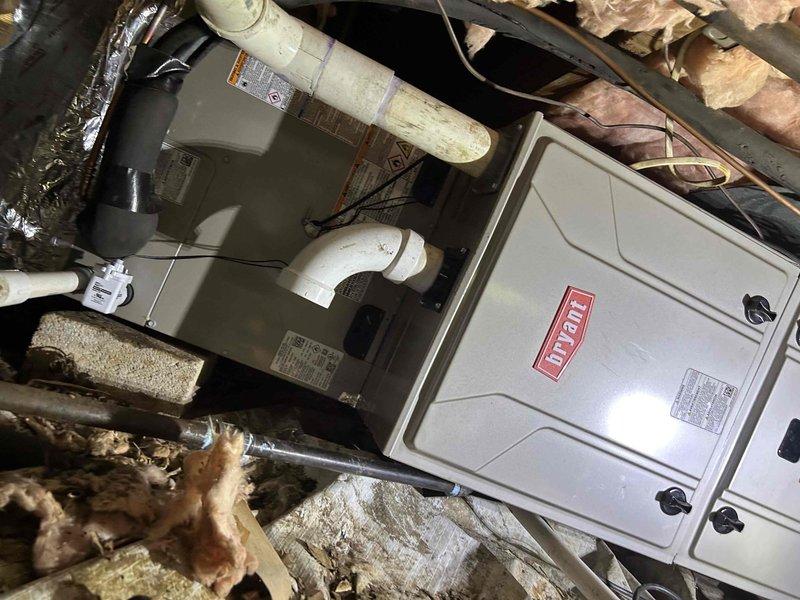 Completed full residential dual fuel HVAC system installation featuring Bryant 16 SEER2 equipment. Installed 97% AFUE 60,000 BTU gas furnace (model GH5SAN530000A) with matching evaporator coil (model 916SA48060M17) in crawl space, requiring removal and reinstallation of crawl space frame to accommodate new furnace dimensions. Installed outdoor condensing unit (model CVAMA3017XMA) on new equipment pad with snow legs for elevation and proper drainage. System includes S200 HP programmable thermostat for optimal climate control and energy management.

Installation incorporated comprehensive safety and efficiency components including trap assembly, SS2 coil drain safety water sensor, "Ceiling Saver" overflow drain pan with secondary water sensor for leak protection, transition fittings to integrate with existing ductwork, and standard-sized air filter rack for routine maintenance access. Outdoor unit installation included electrical whip kit, disconnect box for service accessibility, insula