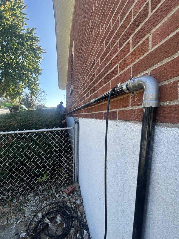 Installed new gas piping run from existing gas line to newly installed standby generator location. Black steel pipe was routed along exterior foundation wall and secured with appropriate mounting brackets, terminating at generator connection point per manufacturer specifications and local code requirements.