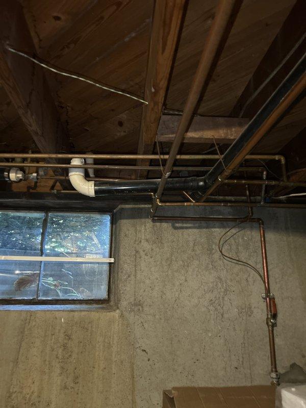 Responded to service call for gas leak detection and pressure testing with gas system operational. Performed comprehensive inspection of gas piping system in basement and attic areas, examining exposed gas lines, connections, and fittings for potential leaks. Conducted pressure test on gas line system to verify integrity and ensure no loss of pressure that would indicate active leaks. Inspected multiple pipe junctions, T-fittings, and connection points throughout the accessible areas, paying particular attention to aged connections showing discoloration. Verified all gas line components were properly secured and functioning safely with system remaining operational throughout testing process.