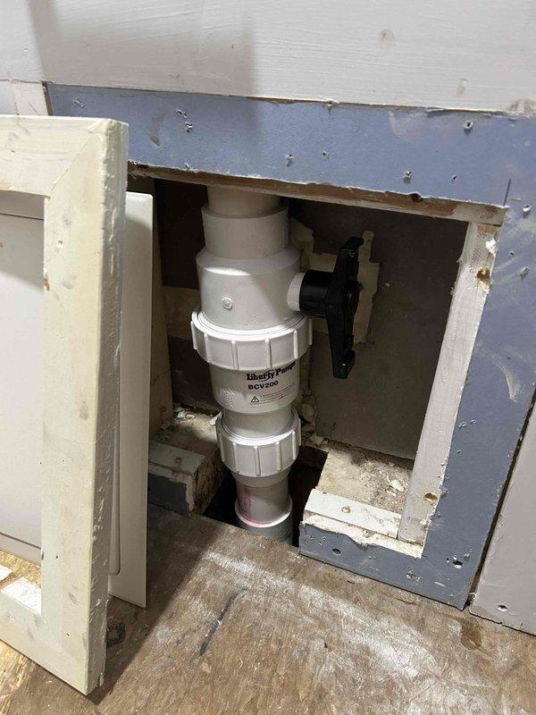 Removed and replaced defective ejector pump system accessed through wall-mounted access panel. Addressed water damage to bathroom flooring caused by pump failure, with visible staining and deterioration to subfloor material. Installed new ejector pump assembly with PVC discharge piping and verified proper drainage function through P-trap configuration. All plumbing connections secured and tested for leaks prior to closing access panel.