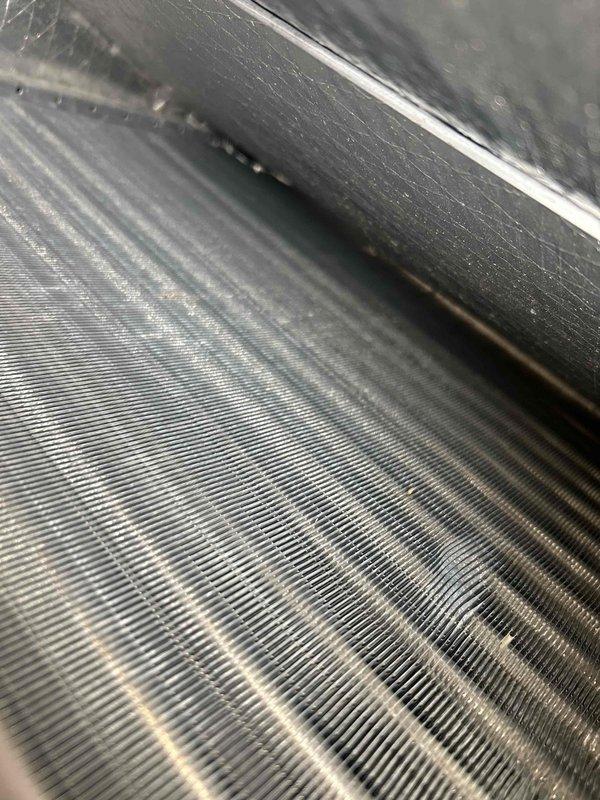 Performed a Gold Level maintenance on a single-system electric split with the indoor unit in an unfinished basement, including inspection of the evaporator coil, which showed light dust and grime buildup with minor fin compression and no signs of frost, ice, or standing water. Verified system performance on R410A using digital manifold and temperature probes: vapor saturation temp of 42.8°F (124.8 psi), liquid saturation temp of 95.6°F (298.9 psi), superheat of 15.2°F, and subcooling of 8.5°F, with supply/return temperatures of 58.0°F and 87.1°F. Readings indicate the system is operating within normal parameters.