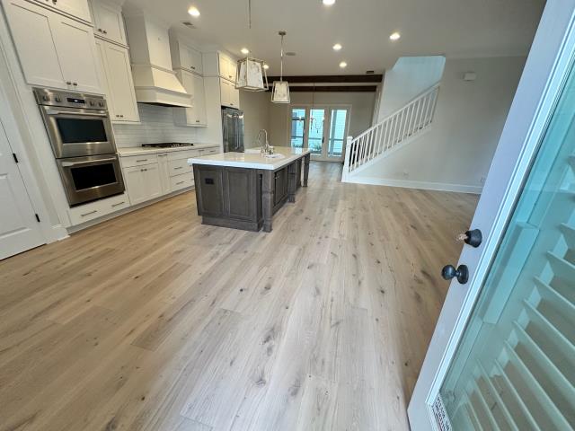 We installed new glue down engineered white oak in this home in Alpharetta, GA and also stained the stairs to match. 