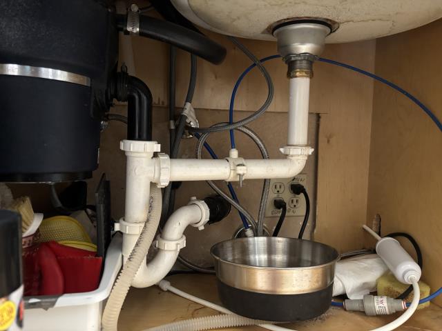 Call out to leak under kitchen sink, found failing basket strainer. Replaced basket strainer and installed new tubular p trap, two part waste and flared tailpiece. One year warranty on workmanship.
