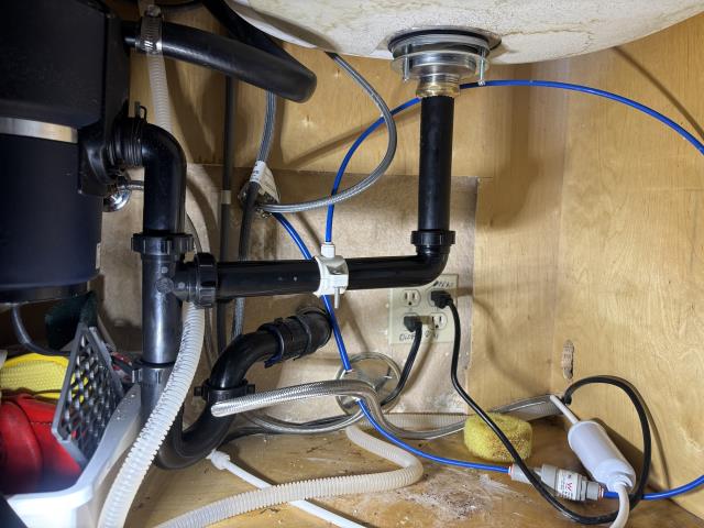 Call out to leak under kitchen sink, found failing basket strainer. Replaced basket strainer and installed new tubular p trap, two part waste and flared tailpiece. One year warranty on workmanship.