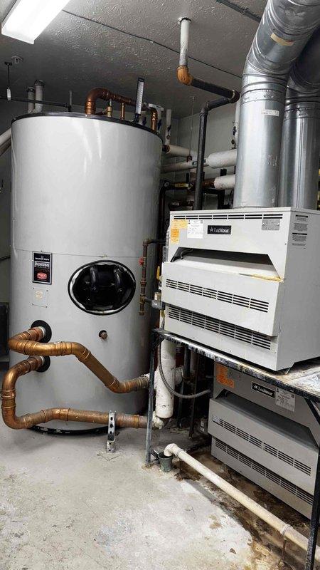 Completed service call to replace mixing valve on boiler system. Accessed mechanical room containing water heater tank and dual HVAC units to perform the necessary replacement. System functioning properly after service.