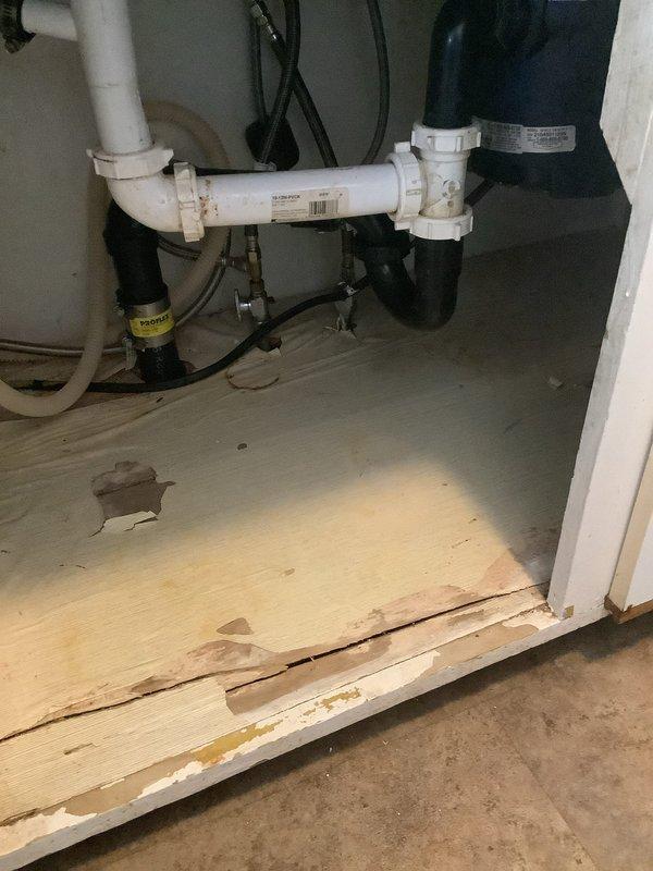 Responded to customer-reported water leak at main meter. Inspected valve assembly in confined space showing signs of corrosion and mineral buildup. Observed significant water damage to cabinet base with warped and deteriorated wood. Replaced faulty main water valve to resolve leak issue.