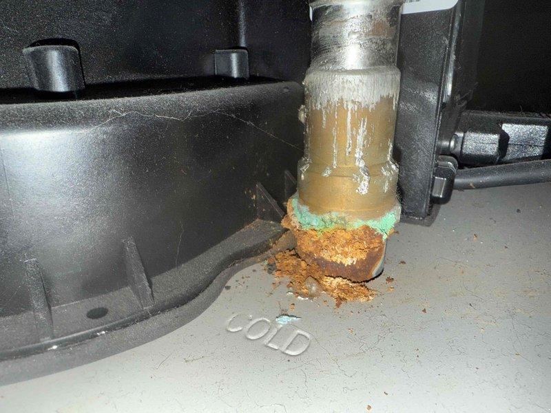 Performed scheduled furnace tune-up on Lennox system. Inspected unit and noted significant corrosion at the cold water supply connection with visible copper oxidation and mineral deposits. System includes furnace with PVC exhaust venting, connected water heater, and air handler with associated ductwork. All components are functional but water supply connection requires monitoring for potential future replacement.