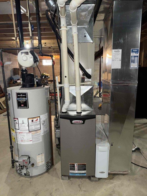 Performed scheduled furnace tune-up on Lennox system. Inspected unit and noted significant corrosion at the cold water supply connection with visible copper oxidation and mineral deposits. System includes furnace with PVC exhaust venting, connected water heater, and air handler with associated ductwork. All components are functional but water supply connection requires monitoring for potential future replacement.