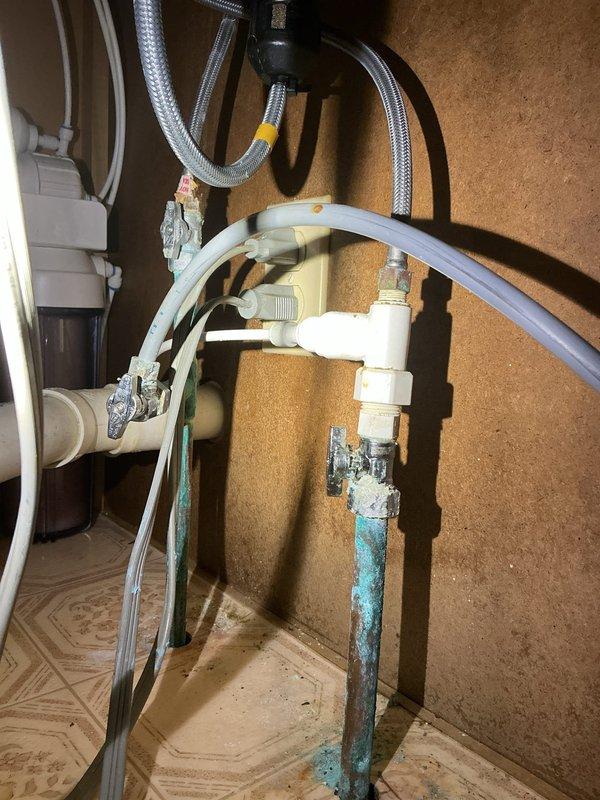 Responded to service call regarding broken pipes under kitchen sink. Discovered significant copper pipe deterioration with blue-green patina indicating advanced corrosion at connection points. Replaced corroded copper supply lines with new fixtures and addressed mineral buildup at pipe joints to prevent future leakage.