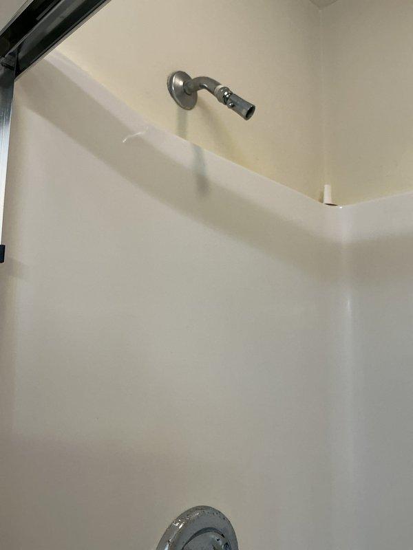 Inspected shower system in 30-year-old home in response to reported major water issue. Upon examination, found functional showerhead and temperature control valve with no visible signs of damage, leakage, or deterioration in the fiberglass/acrylic shower enclosure. No remedial action required as system appeared to be operating normally.