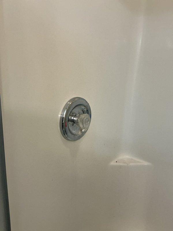 Inspected shower system in 30-year-old home in response to reported major water issue. Upon examination, found functional showerhead and temperature control valve with no visible signs of damage, leakage, or deterioration in the fiberglass/acrylic shower enclosure. No remedial action required as system appeared to be operating normally.