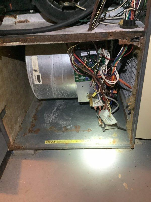 Responded to customer complaint of non-functioning furnace. Inspection of 16-year-old unit revealed significant rust and corrosion throughout the cabinet and housing. Observed worn wiring harness connections to the circuit board and blower motor. Diagnosed issues with the gas valve and control components. System showing multiple signs of age-related deterioration requiring replacement recommendation.