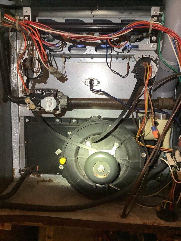 Responded to customer complaint of non-functioning furnace. Inspection of 16-year-old unit revealed significant rust and corrosion throughout the cabinet and housing. Observed worn wiring harness connections to the circuit board and blower motor. Diagnosed issues with the gas valve and control components. System showing multiple signs of age-related deterioration requiring replacement recommendation.