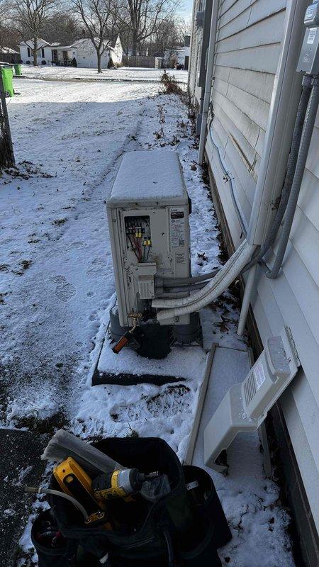 Responded to customer complaint regarding Mitsubishi BTU cooling unit not producing air flow (hot or cold). Upon inspection of outdoor unit, identified significant corrosion and deterioration on pipe fittings and valve assembly, likely due to exposure to winter conditions. Unit also showed signs of moisture accumulation and weathering that was affecting proper operation. Service completed on outdoor condenser to restore proper functionality.