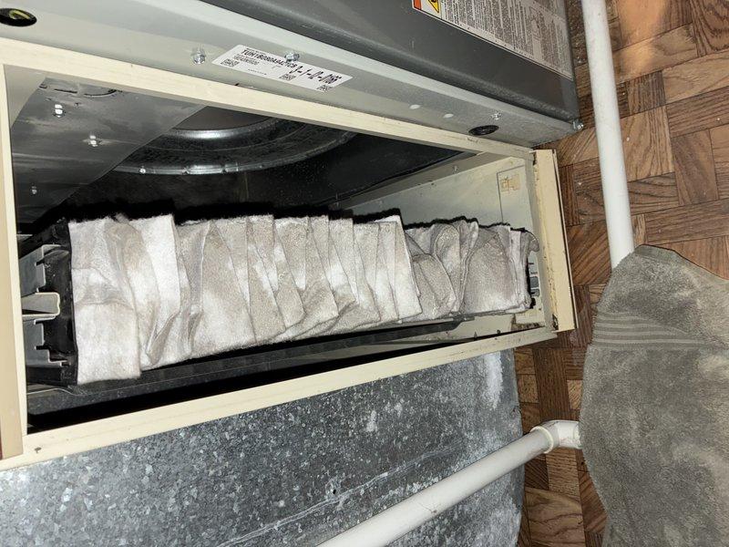 Responded to service call for recurring humidifier leak. Inspection revealed severely clogged air filter causing system restriction, leading to water overflow. Replaced filter, cleaned housing assembly, and verified proper drainage function. System operating normally after service with no further leakage detected.
