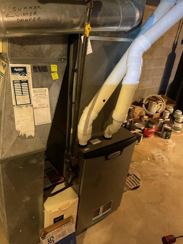 Completed scheduled BS-MVP heating maintenance visit. Inspected basement HVAC system including furnace with PVC ventilation and air handler with proper ductwork connections. Verified seasonal damper settings labeled "SUMMER," "WINTER," and "DAMPER" were correctly positioned for current heating season operation.