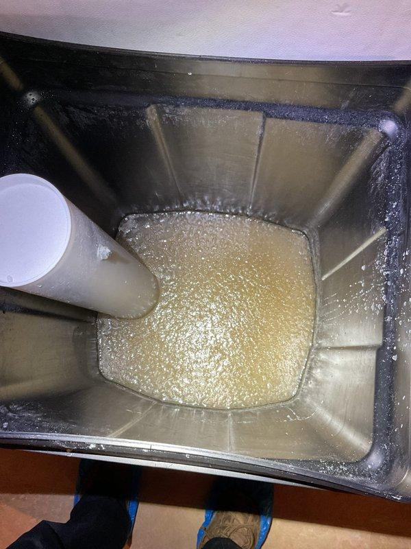 Inspected tankless water heater system and assessed customer's water softener holding tank, which contained brown sludge as reported by homeowner. Documented condition of holding tank through photo evidence showing cloudy, yellowish liquid with sediment buildup. Scheduled follow-up appointment with Craig to address the water softener issues, as customer opted to postpone the tankless water heater flush service until spring.