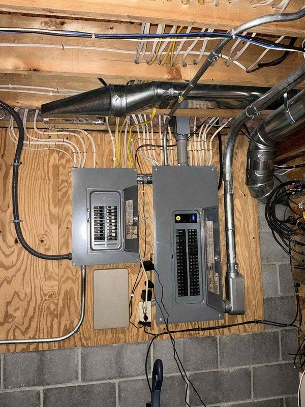 Conducted comprehensive assessment of existing electrical panel setup for potential generator installation. Inspected main electrical panel and adjacent sub-panel mounted on plywood wall, documenting current circuit configuration and load distribution. Evaluated available space and conduit routing options for generator transfer switch integration with existing electrical infrastructure.