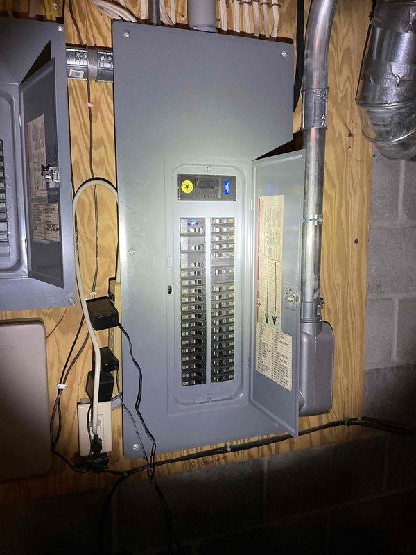 Conducted comprehensive assessment of existing electrical panel setup for potential generator installation. Inspected main electrical panel and adjacent sub-panel mounted on plywood wall, documenting current circuit configuration and load distribution. Evaluated available space and conduit routing options for generator transfer switch integration with existing electrical infrastructure.