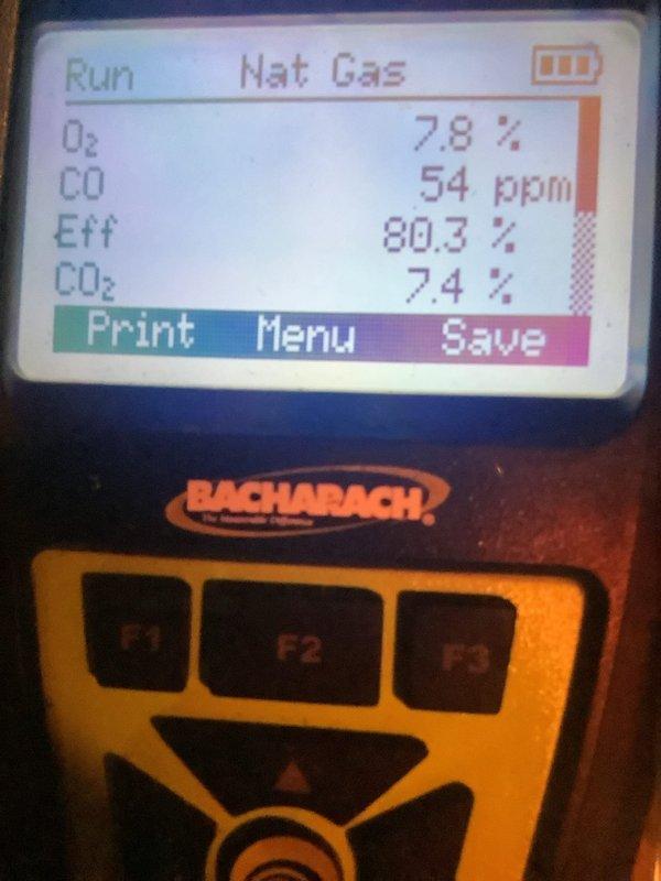 Performed routine maintenance on 6-year-old heating system. Conducted combustion analysis using Bacharach analyzer, which showed O2 at 0%, CO at 54 ppm, efficiency at 80.3%, and CO2 at 7.4%. Used hex key tool to make necessary adjustments to improve system performance.