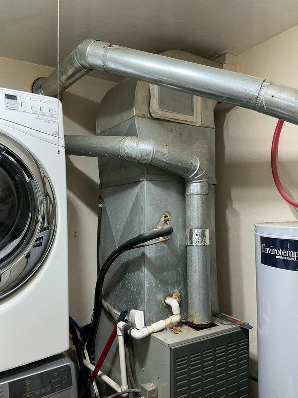 Performed an on-site estimate for furnace replacement in utility room containing existing HVAC system, washing machine, and Envirotemp water heater. Evaluated current ductwork configuration and ventilation requirements. Documented existing setup with photos to develop appropriate replacement proposal.