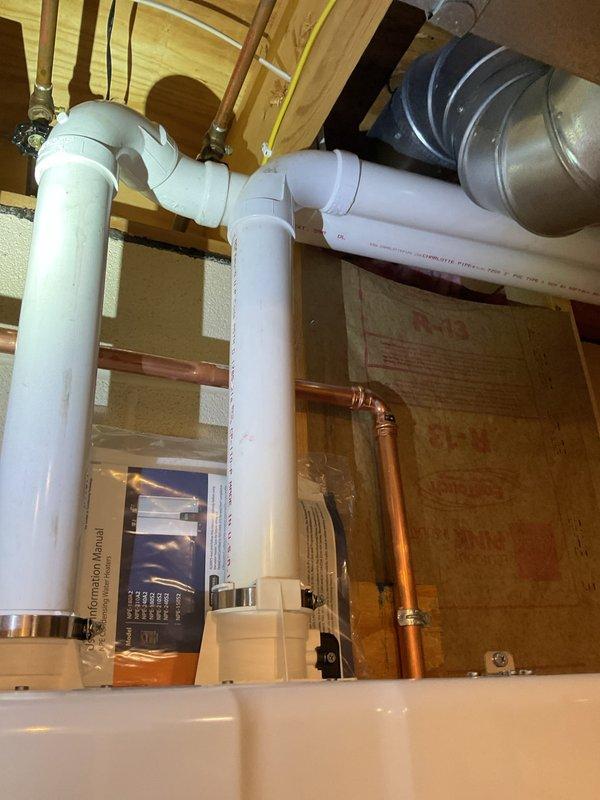 Completed installation of a Navien 240 A2 tankless water heater to replace customer's existing 50-gallon electric unit that was no longer meeting demand. Mounted unit on panel board adjacent to previous heater location, connected condensate line to existing PVC drain pan pipe, installed tee connection to gas line, and ran fresh air/exhaust venting through garage to exit south side of house. Additionally, capped off geothermal lines after the shut-off valves at furnace.