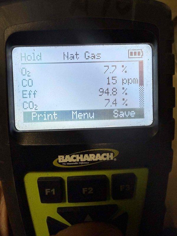 Performed heating system maintenance and combustion analysis using Bacharach gas analyzer, which confirmed system efficiency at 94.8% with CO levels at 15 ppm, O2 at 77%, and CO2 at 7.4%. Inspected flame sensor/electrode assembly and internal wiring connections, finding all components in operational condition.