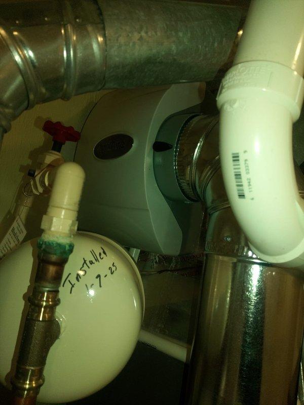 Completed humidifier installation with new plumbing connections integrated into the existing HVAC system. Installation included PVC piping with proper drainage configuration and connection to the home's water supply. System was tested and verified operational with all components properly secured.