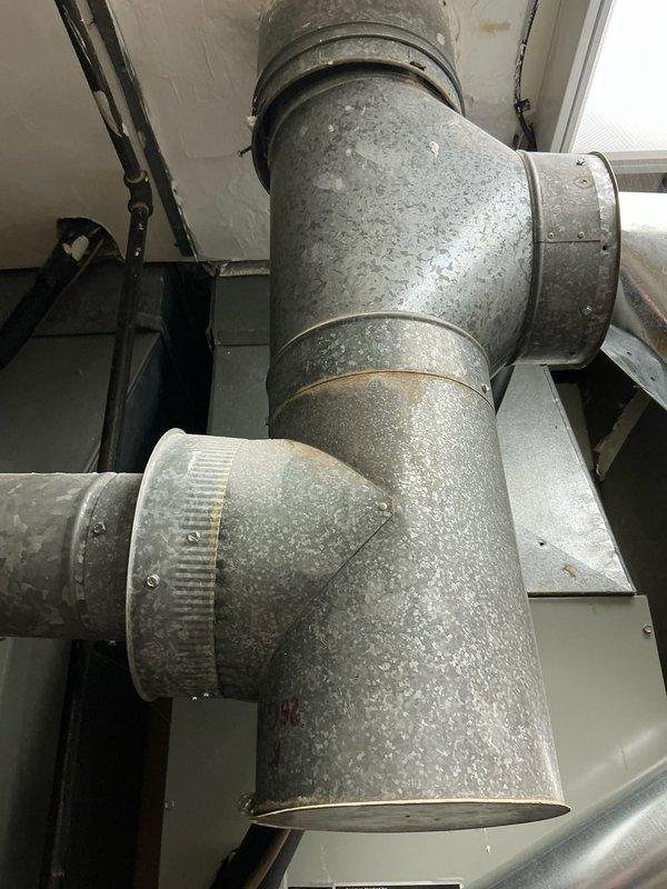 Performed estimate for replacement of two 34-year-old furnaces, one of which has a cracked heat exchanger. Inspection of the existing Lennox system revealed aging ductwork with multiple connections and joints that would need to be addressed during replacement. Photos documented the current installation configuration including the furnace, supply/return connections, and associated control equipment.