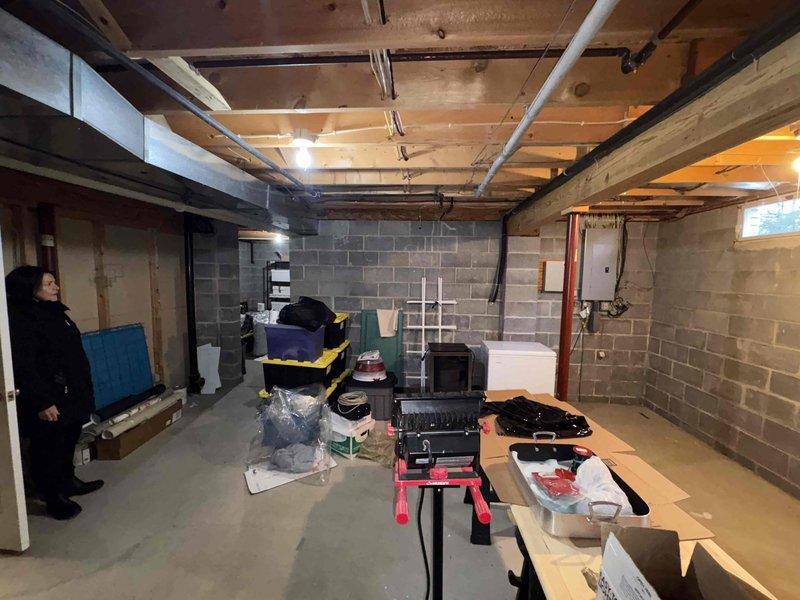Conducted initial site assessment for Kohler generator installation in unfinished basement area. Evaluated existing electrical infrastructure and identified optimal mounting location amid concrete block walls and exposed ceiling joists. Documented spatial constraints and utility pipe locations to determine appropriate generator specifications and installation requirements.