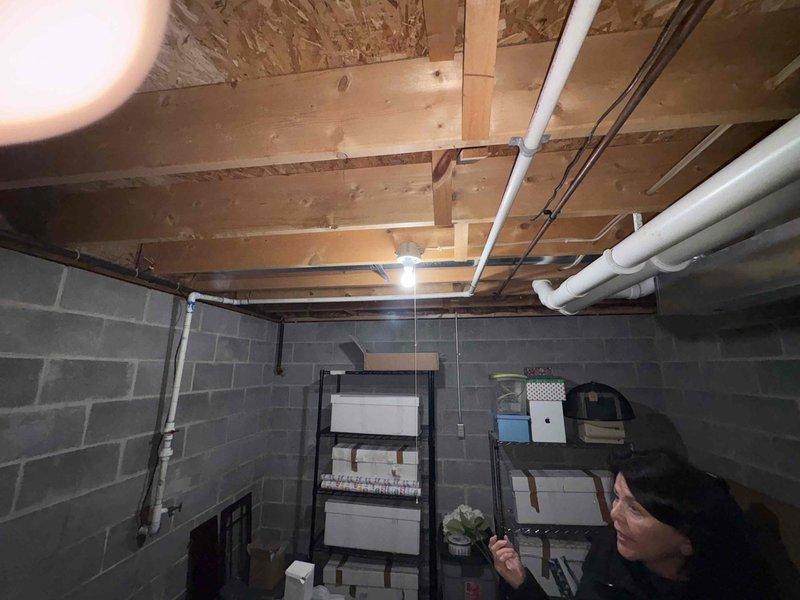 Conducted initial site assessment for Kohler generator installation in unfinished basement area. Evaluated existing electrical infrastructure and identified optimal mounting location amid concrete block walls and exposed ceiling joists. Documented spatial constraints and utility pipe locations to determine appropriate generator specifications and installation requirements.