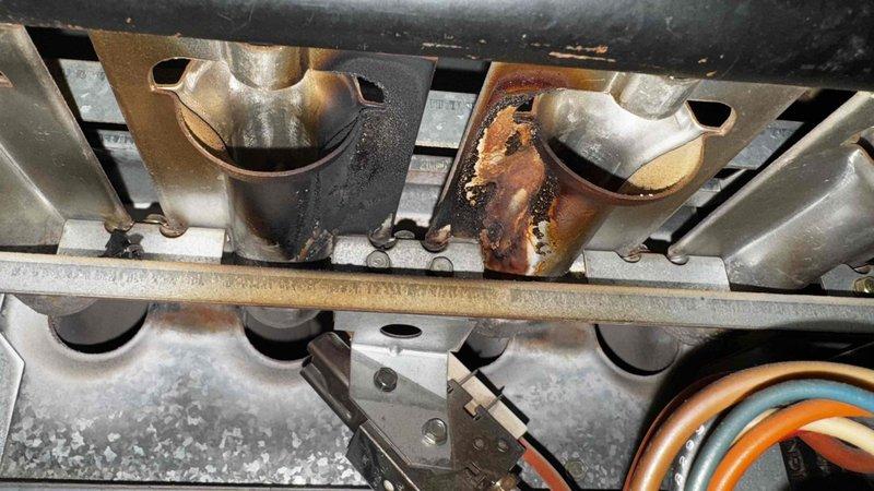 Responded to no heat complaint on 10+ year old system. Inspection revealed severely corroded heat exchanger tube with significant rust damage, compromising system safety and efficiency. Additionally found blower assembly heavily contaminated with dust and debris, restricting proper airflow and causing continuous blower operation. Recommended full system replacement due to age and critical component failure.