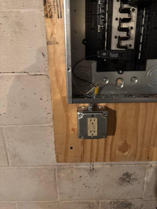 Completed 100 amp 30-circuit panel replacement as requested. Installed new breaker panel on wooden wall with proper wiring configuration, connecting all necessary red and black electrical wires to appropriate circuit breakers. GFCI outlet was installed below the panel in compliance with code requirements.