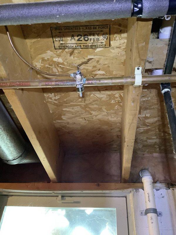Performed tune-up on 29-year-old furnace system. Inspected OSB wall framing and associated plumbing connections. Examined evaporator coil/humidifier pad assembly showing significant mineral deposits and dust accumulation in honeycomb structure; noted calcium buildup on frame and tubing components.