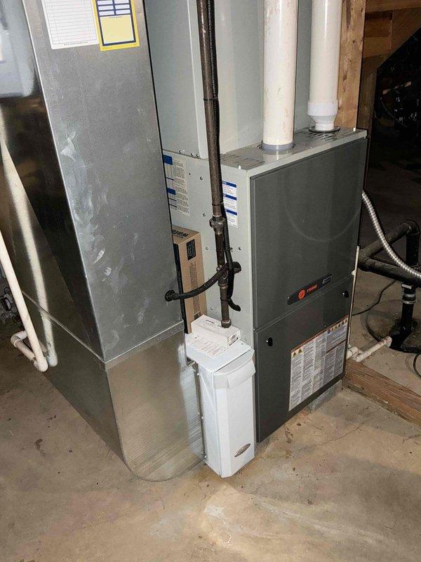 Completed estimate for replacement of aging furnace with cracked heat exchanger and outdated water heater. Customer needs to convert from natural gas well supply to propane due to diminishing gas well output. Documented existing installation in utility room showing current ductwork configuration and connection points for proper system replacement planning.