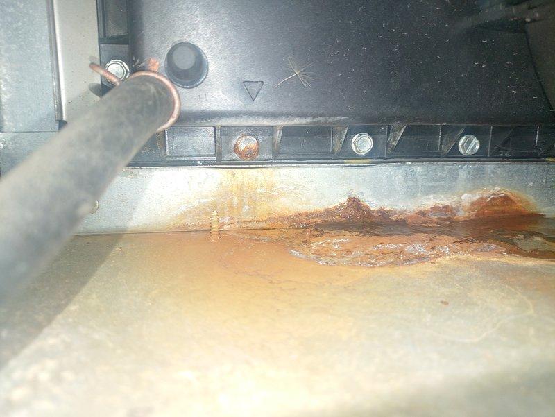 Diagnosed 15+ year old gas furnace with no heat issue. Found multiple ignition failure error codes and significant corrosion damage to heat exchanger components. Observed severe rust deterioration with visible holes forming in the metal surface near copper line connection, indicating end-of-life system failure. Recommended replacement due to safety concerns and uneconomical repair costs for aging unit.