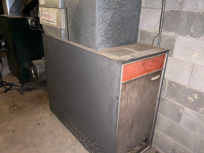 Conducted comprehensive assessment of aging HVAC system in basement, including evaluation of older furnace with visible wear and associated ductwork. Photographed existing equipment to document condition of the green/black furnace unit connected to metallic ductwork and the secondary air handler with distinctive orange-red panel. Prepared separate estimates for furnace replacement and AC installation as requested by customer who has previously consulted another HVAC company.