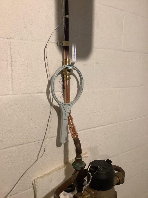 Replaced leaking 3/4" main water line and installed new 1" main shut-off valve. Completed copper pipe installation with appropriate brass fittings on concrete block wall, ensuring proper connections and functionality of the water supply system.