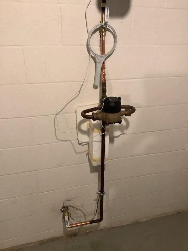 Replaced leaking 3/4" main water line and installed new 1" main shut-off valve. Completed copper pipe installation with appropriate brass fittings on concrete block wall, ensuring proper connections and functionality of the water supply system.