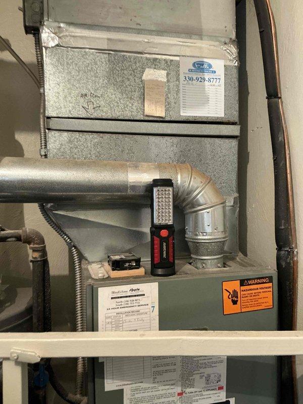 Conducted comprehensive evaluation of 27-year-old residential HVAC system. Inspected existing furnace installation with connected ductwork, noting potential replacement requirements. Documented current setup including metal ductwork configuration and refrigerant line placement for proper system replacement planning.