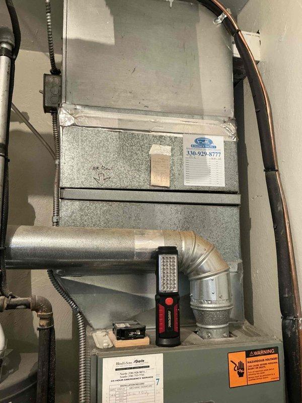 Conducted comprehensive evaluation of 27-year-old residential HVAC system. Inspected existing furnace installation with connected ductwork, noting potential replacement requirements. Documented current setup including metal ductwork configuration and refrigerant line placement for proper system replacement planning.