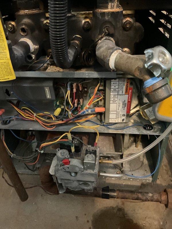 Responded to service call for a 20+ year old gas boiler with no heat and gas odor throughout the residence. Performed combustible gas leak test with UEI EM201B meter, detecting significant gas leak reading of 39.50 at the boiler's gas valve assembly and manifold connections. Inspection revealed severely corroded gas piping and deteriorated control board wiring. Recommended immediate system replacement due to safety hazards and advanced age of equipment.