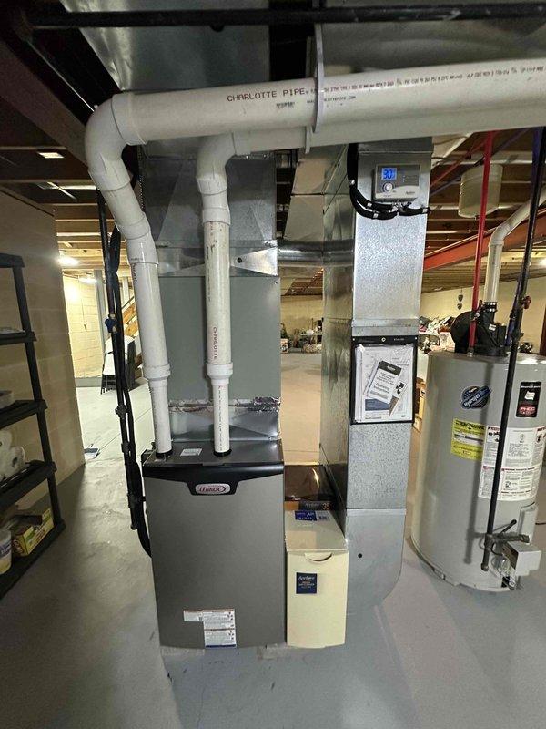 Successfully installed new Lennox 90% efficiency furnace with proper venting through white PVC exhaust pipes. Completed all connections to existing ductwork and verified system operation before finalizing installation.