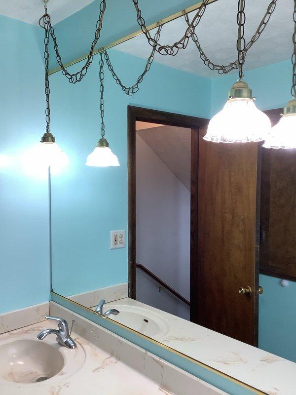 Responded to service call for non-functioning bathroom lighting. Inspected the 50+ year old electrical system and identified faulty wiring connections at the dual toggle switch/GFCI combo plate. Restored proper electrical connections, tested circuit functionality, and verified all pendant lights above vanity mirror now operating correctly. Left installation in safe working order.