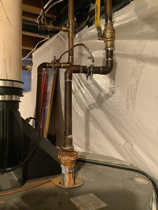 Inspected 40-gallon tank water heater in basement utility area after customer complaint. Identified significant corrosion and mineral buildup on copper supply piping and connections. Cleaned affected areas and tested system functionality. Recommended monitoring the corroded connection point for potential future replacement.